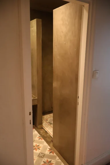 Avant, douche Vue d'un espace intérieur avec des cloisons en béton et un sol carrelé.