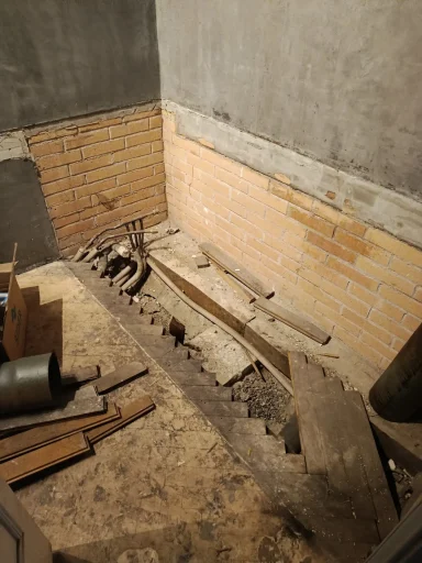Pendant, baignoire Salle en cours de rénovation avec des murs en briques et des débris de construction.