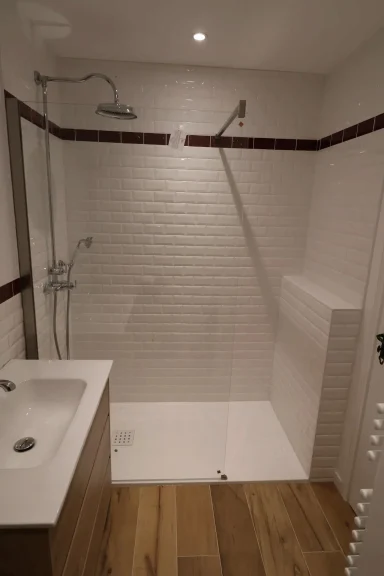 Après, douche Douche moderne avec carrelage blanc et sol en bois, éclairage doux.